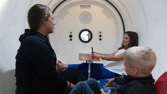 Two people inside a hyperbaric chamber for home use